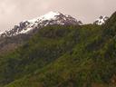 Snowy peaks peeking over green hills.